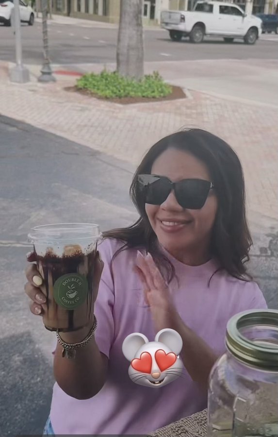 Customer holding a Double H Coffee Co. iced coffee, waving