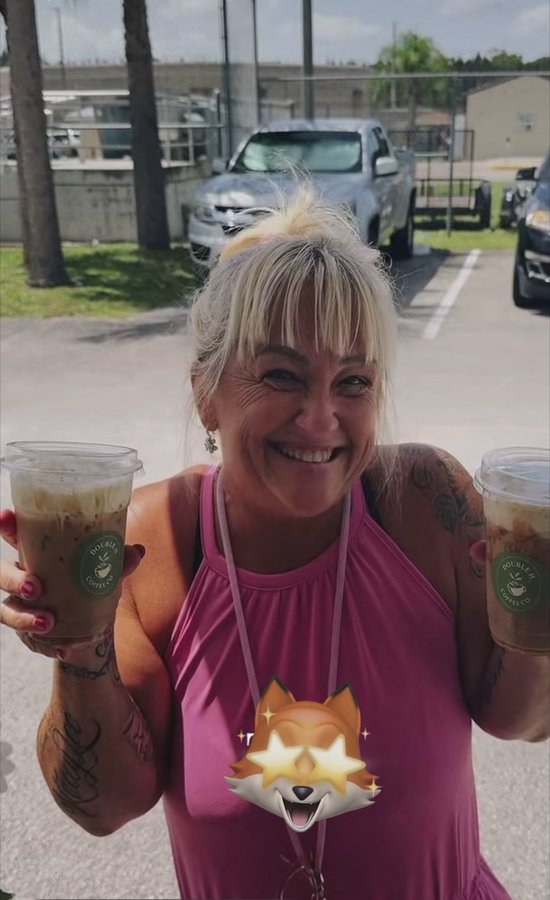 Smiling customer holding a Double H Coffee Co. iced drink