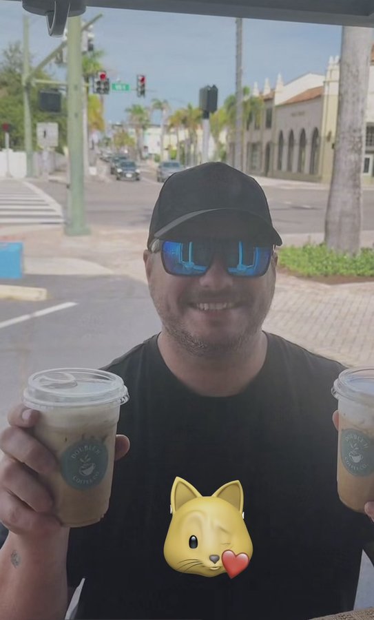 Customer holding a Double H Coffee Co. iced coffee near the trailer